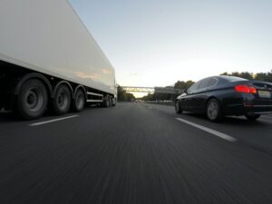 truck and car driving on road before crash, may need truck accident lawyer for injuries