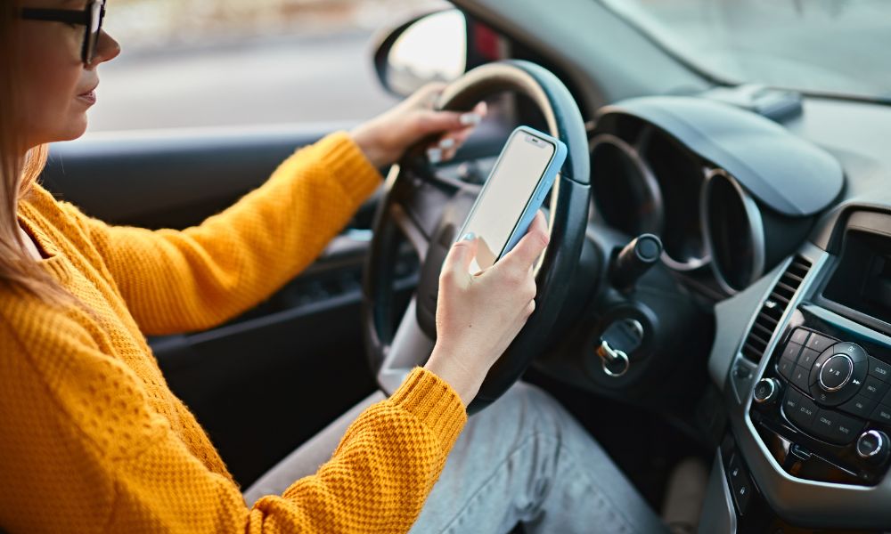 woman driving car and texting illegally as per sugar land car accident lawyer